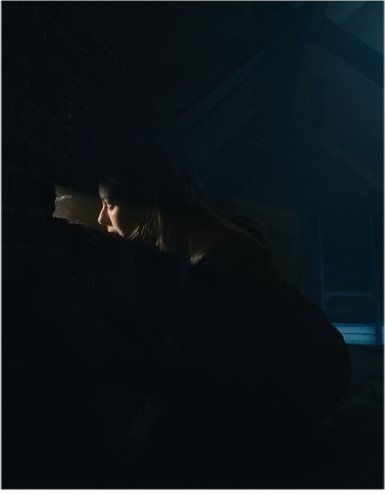 Maddy crouched in the shadows of the attic
